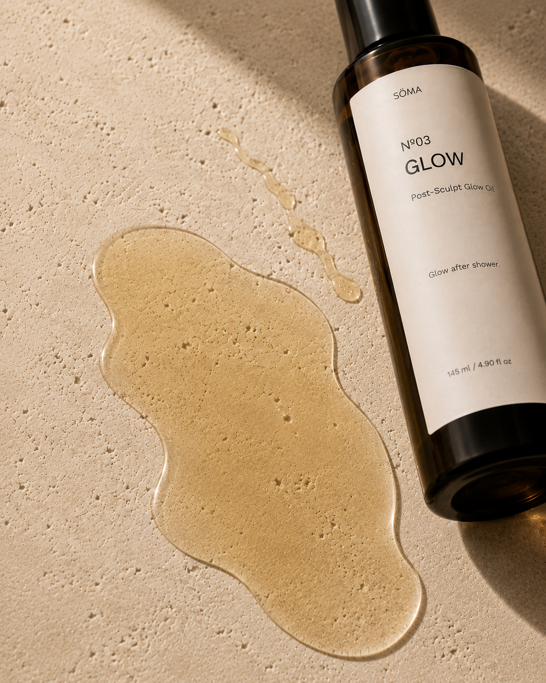 SÖMA N°03 Post-Sculpt Glow Oil with a transparent body oil texture, showcasing its lightweight, silky finish and botanical ingredients on natural stone.